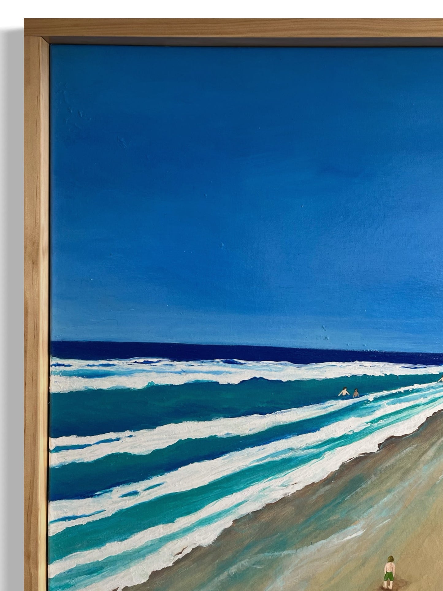 Original acrylic painting on canvas of a beachwalk through Torquay, with swimmers in the clear water and others relaxing on the sandy shore. The scene captures the tranquil coastal atmosphere, with soft waves and a warm, sunlit setting. The artwork is framed with a natural pine timber border close-up.
