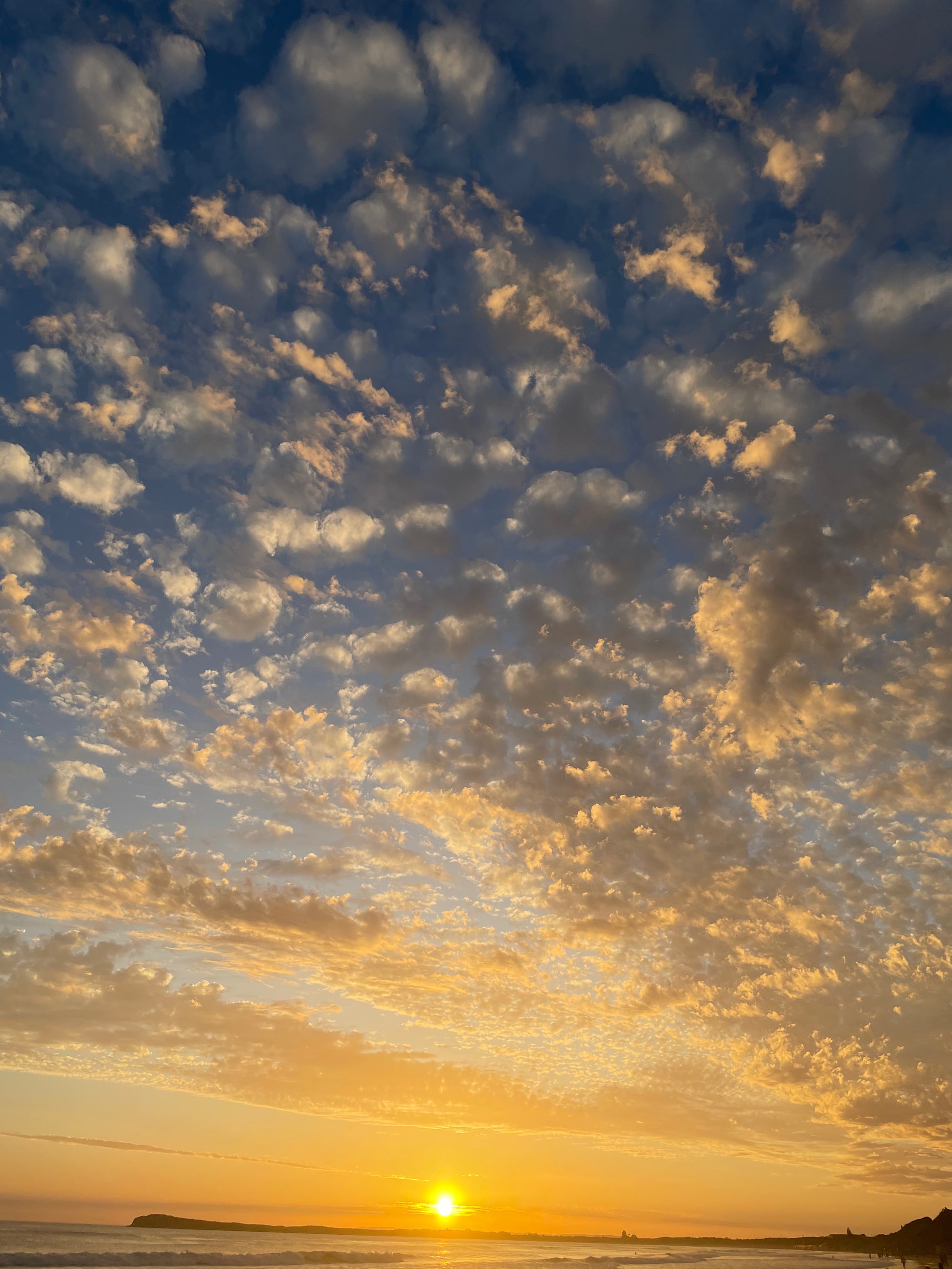 A high quality photograph of an Aussie night sunset, showcasing the stunning contrast between the vibrant sun and the blue sky. The image captures the beauty of Australia's coastal landscape. Printed on premium material for a refined and elegant finish.
